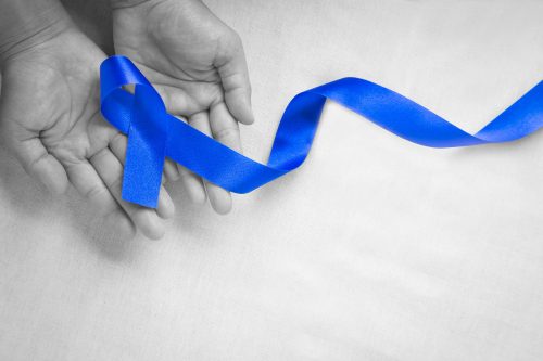 hands-holding-deep-blue-ribbon-white-fabric-with-copy-space ד